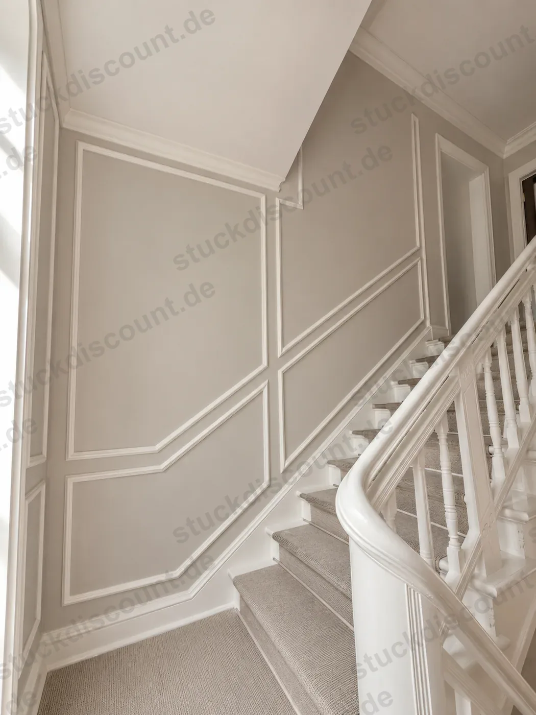 Treppenhaus mit Wandvertäfelung aus Stuckleisten entlang der Treppe