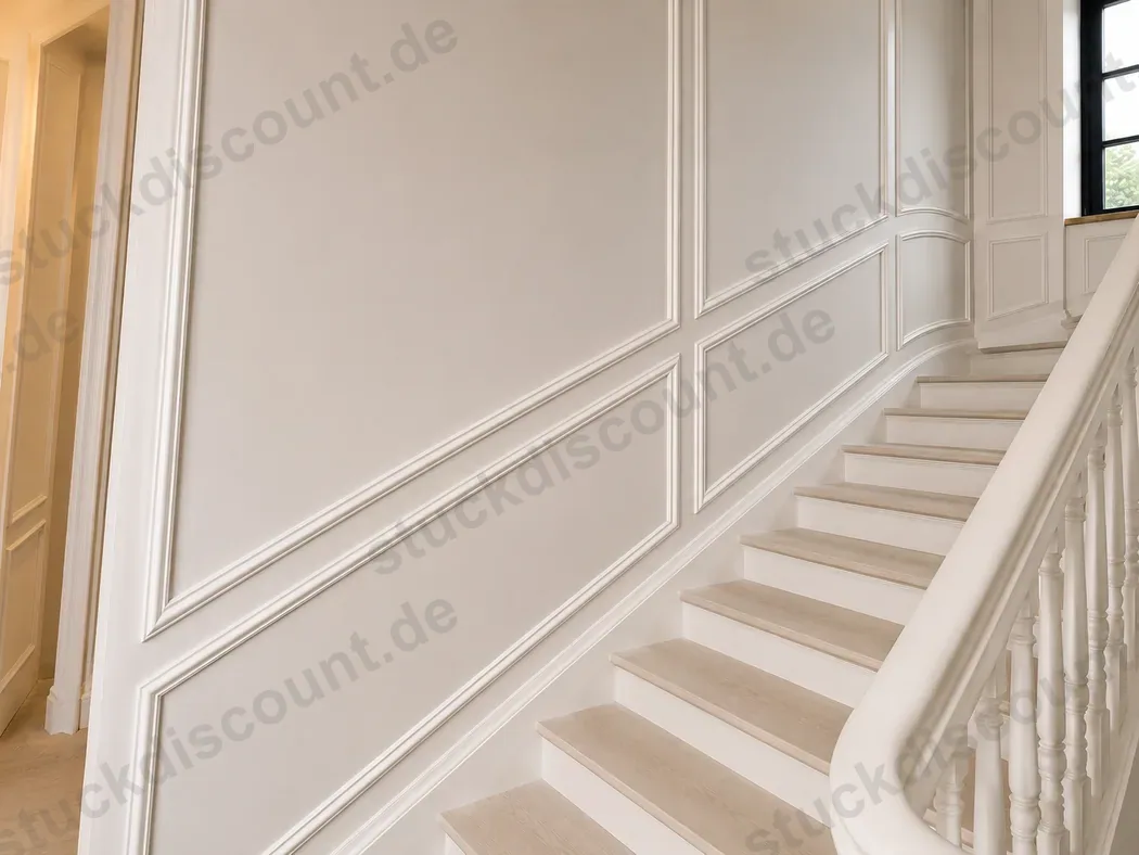 Treppenhaus mit klassischen Wandfeldern und weißem Geländer
